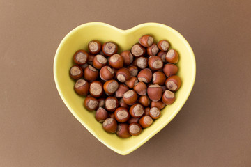 Hazelnuts in yellow heart-shaped plate