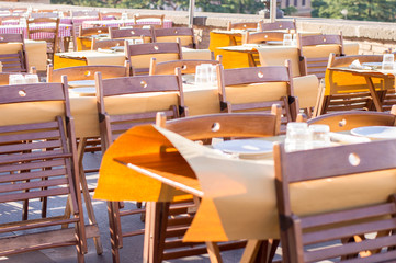 Empty restaurant tables lit by sunlight