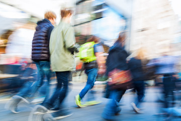 Menschen beim Einkaufsbummel in der Fußgängerzone in Bewegungsunschärfe