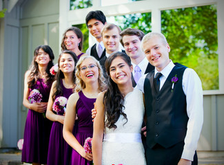 Wedding party standing outdoors with bride and groom