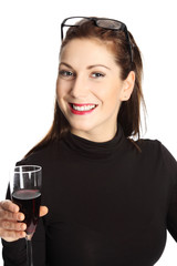 Woman in her 20s standing wearing a black sweater with glasses on her head, holding a wine glass smiling towards camera. White background.