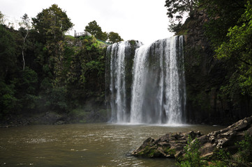 Whangarei falls from the river surface level on a cloudy day.