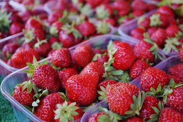 Juicy sweet red strawberries in containers at the farmers market