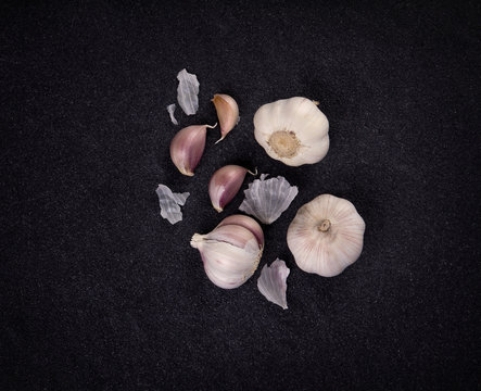  a still life arrangement of Three whole garlic bulbs grouped on