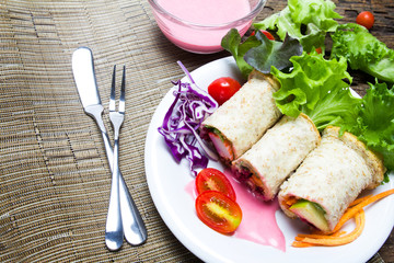 fresh whole wheat bread wraps with vegetables and fruit on the p