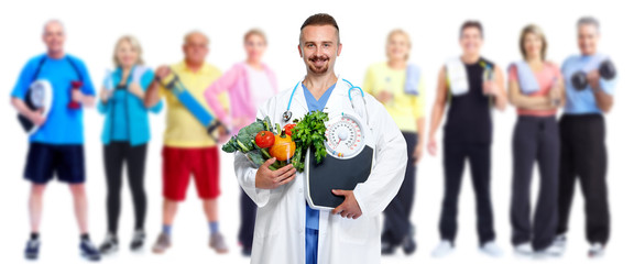 Doctor with vegetables and group of fitness people.