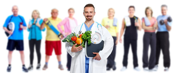 Obraz premium Doctor with vegetables and group of fitness people.