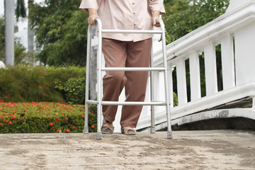 senior woman with walker in park.