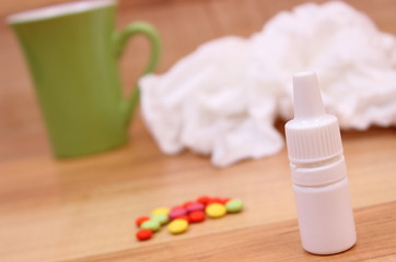 Pills and nose drops for colds, used handkerchiefs and hot tea