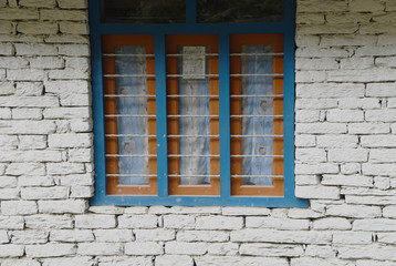 Fototapeta na wymiar closed up the blue wood windows with white brick wall, in villag