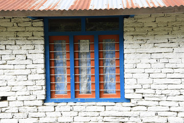 closed up the blue wood windows with white brick wall, in villag