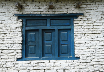 Fototapeta na wymiar closed up the blue wood door with brick wall, in village Nepal