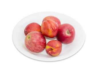 Several red apples and nectarines on a white dish