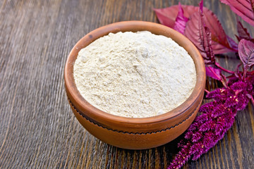 Obraz na płótnie Canvas Flour amaranth in clay bowl on board