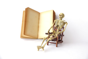 Stock Photo:. Human skeleton Sit on a chair With old books