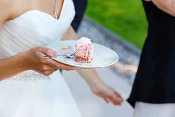 Bride holding delicious wedding cake