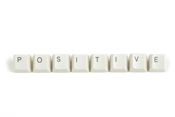 positive from scattered keyboard keys on white