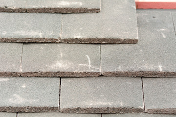 Rows of roof tiles being fitted to wooden battens