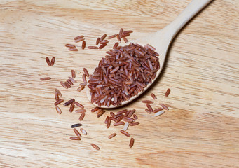 red rice on wooden spoon