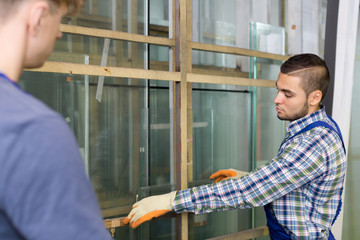 Couple of workers measuring glass