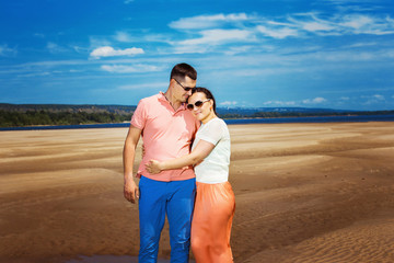 Beautiful happy couple is emracing outdoors at summer beach