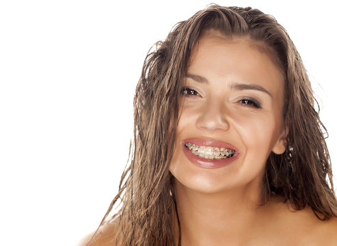 young woman with wet hair and braces posing in the studio