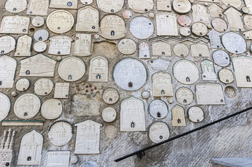 Bakhchisaray , Crimea , Russia . Holy - Assumption Orthodox cave Monastery .The entire wall along the stairs is occupied by reliefs of monasteries and churches from different parts of the world .
