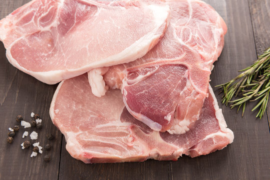 Top view raw fresh meat and salt, pepper on wooden background