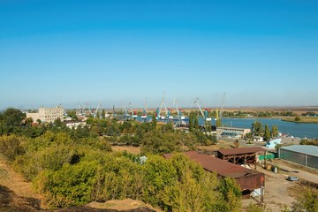 Fototapeta na wymiar Water area of the Don river and industrial port with crane, established in coastal street in Azov.