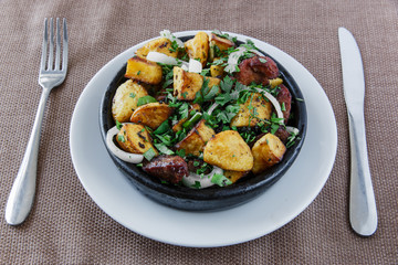  baked roast potatoes with meat in a clay bowl