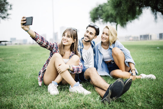 Three friends, two girls and a man taking a self portrait in the