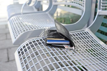 Foto op Canvas Verlorener Geldbeutel liegt auf einer Bank © photophonie