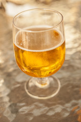Misted glass of beer on a glass table in a bar