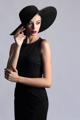 high fashion portrait of elegant woman in black hat.