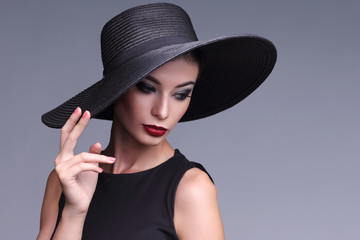high fashion portrait of elegant woman in black hat.