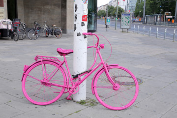 Pink bicycle padlocked to post in Berlin, Germany, Europe
