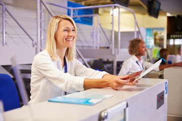Staff Working At Airport Check In Desk