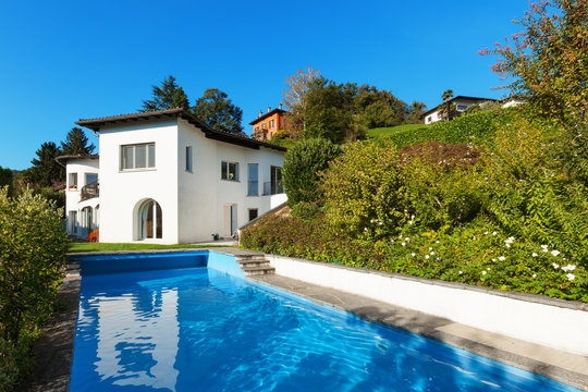 exterior of a single-family house with a wonderful pool of blue water