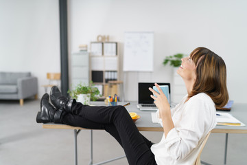 frau entspannt am arbeitsplatz mit einer tasse kaffee © contrastwerkstatt