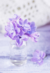 Obraz na płótnie Canvas Lilac flowers in a small glass bottle