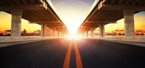 Foto op Plexiglas opkomende zon achter perspectief op bouw van brugram en asp © stockphoto mania