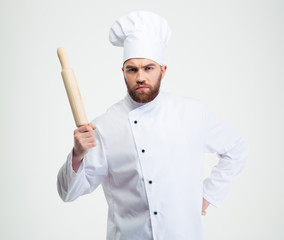 Serious male chef cook holding a rolling pin