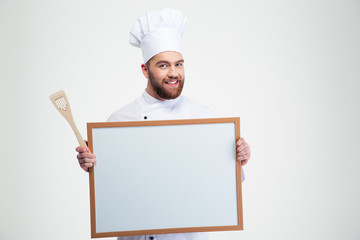 Smiling male chef cook holding blank board