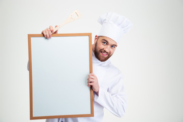 Male chef cook holding blank board