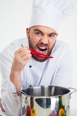 Male chef cook holding red pepper