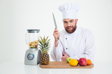 Male chef reading to cutting vegetables
