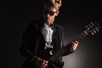 cool young guitarist playing his electric guitar
