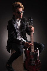 Obraz premium seated guitarist poses for the camera