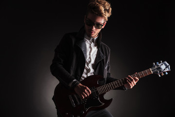Obraz premium dramatic picture of a young rock and roll guitarist