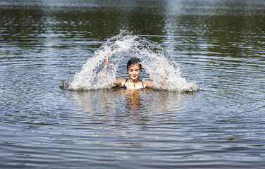 swimming woman makes a water fountain